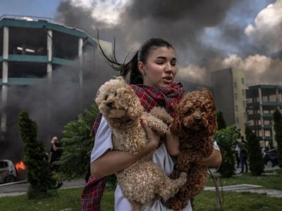 Девушка выбегает из дома, держа на руках домашних животных. Фото: cloudfront.net